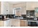 Well-lit kitchen with black countertops, stainless steel appliances, and white cabinetry at 1423 Dahlia St, Denver, CO 80220