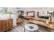 Open-concept living area with a sofa, unique furnishings, and a view into the modern kitchen space at 1423 Dahlia St, Denver, CO 80220