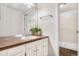 Bathroom featuring tile floors, white cabinets, and a large mirror at 11689 Elk Head Range Rd, Littleton, CO 80127