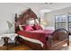 Inviting primary bedroom with wood floors, large window and a decorative headboard at 11689 Elk Head Range Rd, Littleton, CO 80127