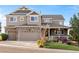 Charming two-story home featuring a three-car garage, brick accents, and a welcoming front porch at 2631 Red Hawk Ridge Dr, Castle Rock, CO 80109