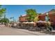 Outdoor dining area with tables and umbrellas in front of commercial buildings, inviting pedestrian traffic at 8400 W 52Nd Ave, Arvada, CO 80002