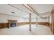 The unfinished basement has a fireplace, tile floors, and support beams at 7264 S Platte Canyon Dr, Littleton, CO 80128