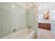 This bathroom has a tub and shower combo and vanity with wooden cabinets at 7264 S Platte Canyon Dr, Littleton, CO 80128