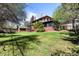 A well-maintained backyard with mature trees and a lush green lawn, perfect for outdoor activities and relaxation at 1317 Birch St, Denver, CO 80220