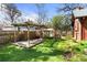 Backyard featuring lawn, trees, fence, and a pergola at 1317 Birch St, Denver, CO 80220