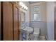 Powder bathroom featuring pedestal sink and toilet with floral wallpaper at 1317 Birch St, Denver, CO 80220