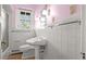 Bathroom featuring pedestal sink, tiled walls and floors and a window at 1317 Birch St, Denver, CO 80220