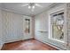 Cozy bedroom with floral wallpaper, wood floors, and a door to balcony at 1317 Birch St, Denver, CO 80220