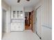 Kitchen has white tile floor, glass-door cabinets, and access to the dining room at 1317 Birch St, Denver, CO 80220