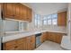 Sunlit kitchen area featuring a stainless steel dishwasher and sink with a window offering natural light at 1317 Birch St, Denver, CO 80220