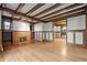 Open living room showcasing hardwood floors, beamed ceilings, a fireplace, and classic wood trim at 1317 Birch St, Denver, CO 80220