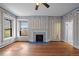Empty living room featuring a decorative fireplace, hardwood floors, and natural light from the window at 1317 Birch St, Denver, CO 80220