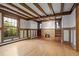 Spacious living room boasting hardwood floors, built-in bookshelves, a cozy fireplace, and expansive windows at 1317 Birch St, Denver, CO 80220
