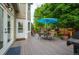 A wooden back deck features an outdoor table and chairs, and a blue umbrella for shade at 7176 S Pierson St, Littleton, CO 80127