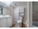 This bathroom has a white vanity, toilet and cabinet, complementing the neutral-tiled flooring and white walls at 7176 S Pierson St, Littleton, CO 80127