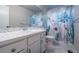Bright bathroom with blue floral shower curtain and white vanity at 7176 S Pierson St, Littleton, CO 80127