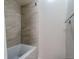 A neutral-toned bathtub shower with tile and white walls create a bright atmosphere at 7176 S Pierson St, Littleton, CO 80127