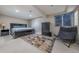 A bright basement bedroom with a large bed, dark furniture, natural light and a minimalist color palette at 7176 S Pierson St, Littleton, CO 80127