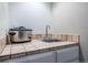 Kitchen with a ceramic tile countertop and a sink at 7176 S Pierson St, Littleton, CO 80127