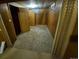 View of the partially finished basement showcasing wood paneling and older flooring at 12058 E Virginia Pl, Aurora, CO 80012