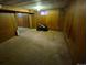 View of the partially finished basement showcasing wood paneling and old carpeting at 12058 E Virginia Pl, Aurora, CO 80012