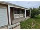 Inviting front porch with decorative detailing, and an attached garage at 12058 E Virginia Pl, Aurora, CO 80012