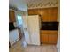 Well-lit kitchen featuring a refrigerator with water dispenser, wooden cabinets, and tile floors at 12058 E Virginia Pl, Aurora, CO 80012