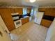 Spacious kitchen featuring oak cabinets, tile flooring, and modern appliances at 12058 E Virginia Pl, Aurora, CO 80012