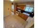 Charming kitchen featuring tile flooring, oak cabinetry, and modern appliances at 12058 E Virginia Pl, Aurora, CO 80012