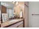 Bathroom featuring a granite countertop, wood-look cabinet, and ample lighting with a shower and tub combo at 324 Wright St # 304, Lakewood, CO 80228