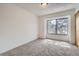 A simple bedroom with neutral carpet and a large window bringing in natural light at 324 Wright St # 304, Lakewood, CO 80228