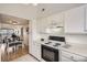 Cozy kitchen featuring white cabinetry and updated appliances, and a window overlooking the exterior at 324 Wright St # 304, Lakewood, CO 80228