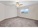 This bright bedroom offers a ceiling fan, neutral walls, carpet and an outside view from the window at 15652 W 79Th Pl, Arvada, CO 80007