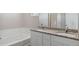 Bathroom featuring double sinks, granite countertops, and a soaking tub at 7322 Green River Ave, Frederick, CO 80530