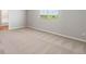 A sunlit bedroom with neutral carpeting, a large window, and ample space for furniture at 7322 Green River Ave, Frederick, CO 80530