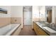 Modern bathroom with double sinks, soaking tub, and walk-in shower at 1620 Little Raven St # 109, Denver, CO 80202
