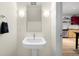 Simple bathroom with pedestal sink and view into the kitchen at 1620 Little Raven St # 109, Denver, CO 80202