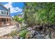 Backyard featuring a pond, stone firepit area, mature trees, and house elevation on a sunny day at 21416 E Ottawa Cir, Aurora, CO 80016