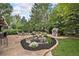 Backyard featuring lush landscaping, a tranquil pond, playhouse, and stone patio with comfortable seating at 21416 E Ottawa Cir, Aurora, CO 80016
