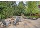 Backyard features an outdoor fire pit with seating, a pond feature, mature trees and a playhouse at 21416 E Ottawa Cir, Aurora, CO 80016