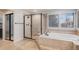 This bathroom has a bathtub, a walk-in shower with a black frame, and a window with shutters at 21416 E Ottawa Cir, Aurora, CO 80016
