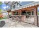 Outdoor kitchen on stone patio with bar seating, wood paneled ceiling, and TV, perfect for entertaining at 21416 E Ottawa Cir, Aurora, CO 80016