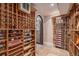 Beautiful wine cellar with ample storage, custom wooden racks, tile flooring, and a wrought iron gated entrance at 21416 E Ottawa Cir, Aurora, CO 80016