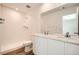 Bright bathroom featuring a double sink vanity with quartz countertops, white cabinetry, and a walk-in shower at 15296 Fillmore St, Thornton, CO 80602