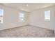 Bright bedroom featuring neutral carpet, white walls, and natural light from three windows at 15296 Fillmore St, Thornton, CO 80602