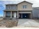 New two-story home with gray and beige siding, covered porch and attached two-car garage with concrete driveway at 15296 Fillmore St, Thornton, CO 80602