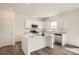 Sunlit kitchen with white cabinetry, stainless steel appliances, central island and modern lighting fixtures at 15296 Fillmore St, Thornton, CO 80602