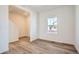Cozy living area featuring wood-look flooring, white walls, modern trim, and a bright window at 15296 Fillmore St, Thornton, CO 80602