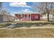 Cozy home with a red brick facade, white trim, and a cheerful, covered front porch at 2567 Benton St, Edgewater, CO 80214